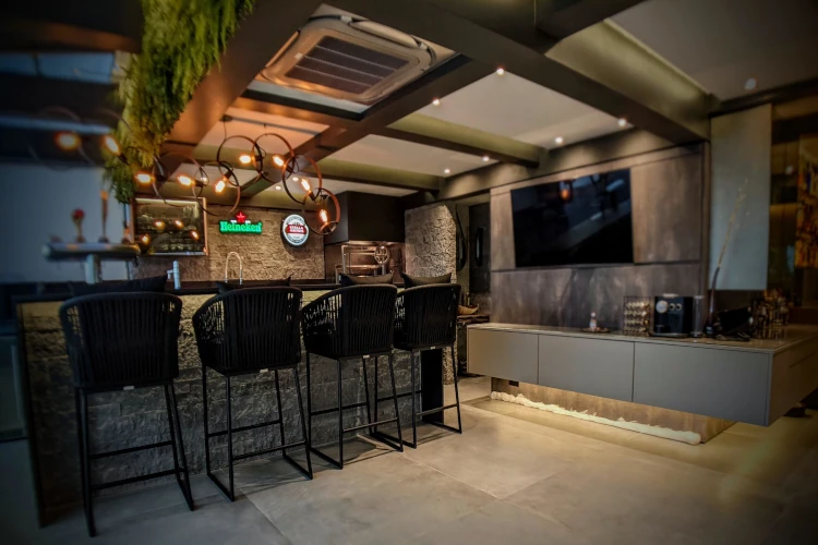 Arquiteto da KAMOARQ apresentando um projeto 3D de cozinha integrada com sala para clientes, destacando a personalização.
